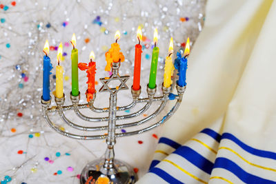 High angle view of colorful candles with confetti and toy blocks on table