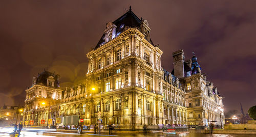 Low angle view of illuminated building against sky at night