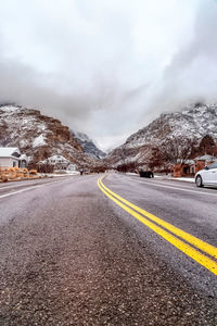 Road by mountain against sky