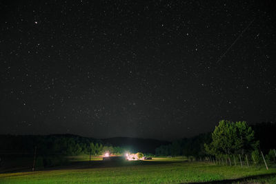 Scenic view of illuminated field against sky at night