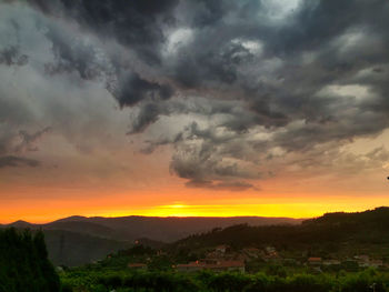 Scenic view of silhouette mountains against dramatic sky