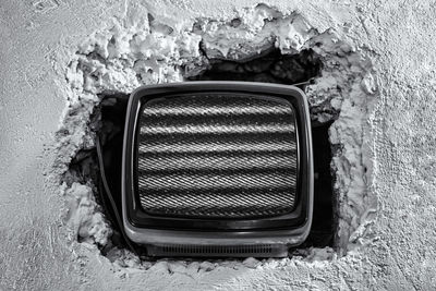 Close-up of rolled up rope in weathered wall