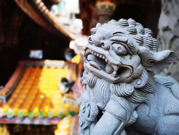 Close-up of buddha statue against building