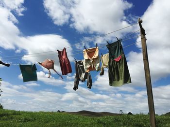 Low angle view of clothes hanging on clothesline against sky