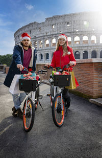 A young couple resting from a day of shopping in rome with bicycles full of bags and gifts.