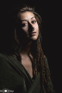 Portrait of beautiful woman against black background