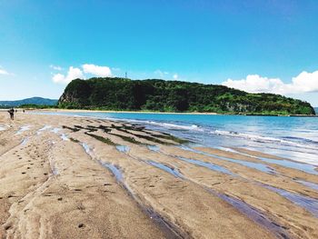 Scenic view of beach against blue sky