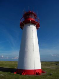 Low angle view of lighthouse on field against sky