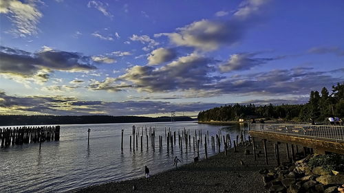 Pier over lake against sky during sunset