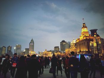 Group of people in front of buildings against sky