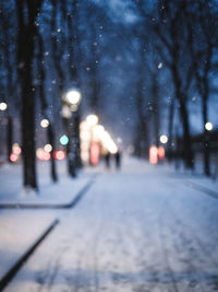 Cars on illuminated street in city during winter