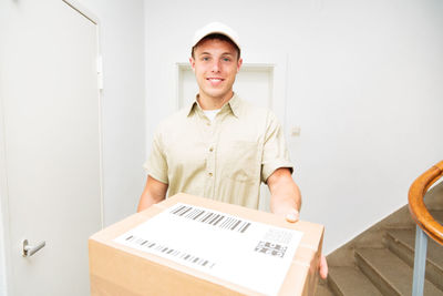 Portrait of smiling young woman standing in box