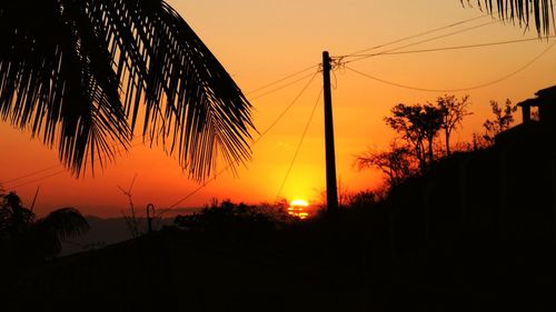 Low angle view of silhouette trees against sunset sky