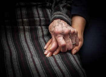 Midsection of granddaughter and grandmother holding hands