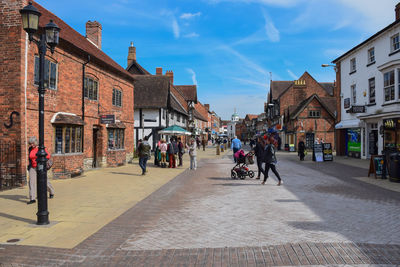 People on street amidst buildings in city