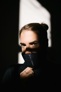 Portrait of young woman against wall