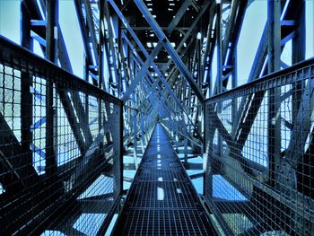 Narrow footbridge along grid railings