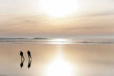 People long-distance skating at sunset, vanern, sweden