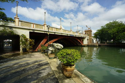 Bridge over river against cloudy sky