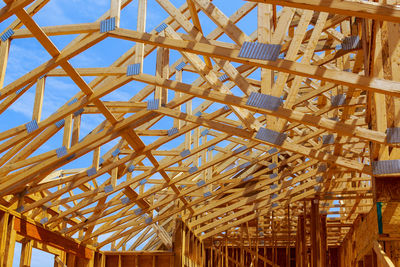 Low angle view of roof beam against sky