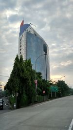 Trees by city against sky