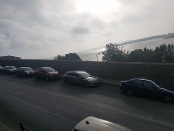 Cars on road against sky in city