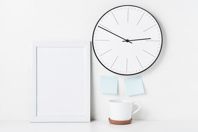 Close-up of clock against white wall