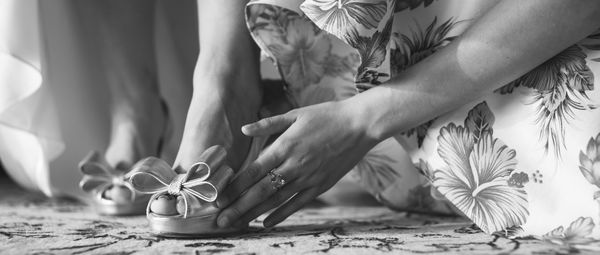 Low section of woman wearing shoes on table