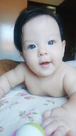 Close-up portrait of cute baby boy on bed