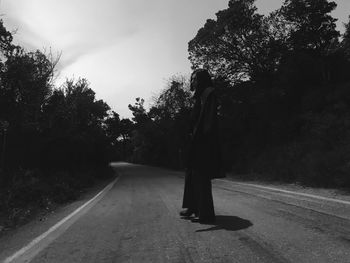 Rear view of woman walking on road