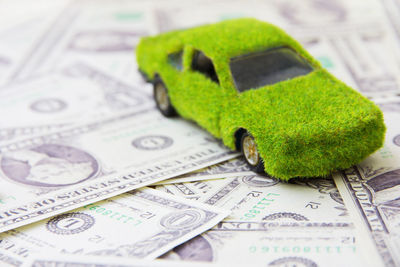 Close-up of green car on paper currency