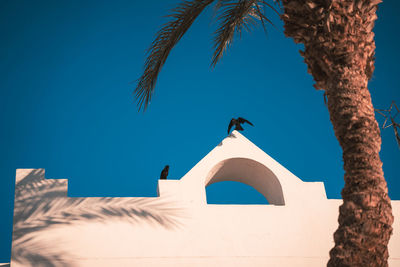 Low angle view of lighthouse against clear blue sky