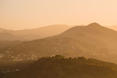 Scenic view of mountains against clear sky during sunset