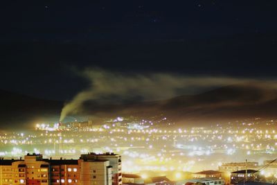 High angle view of illuminated cityscape against sky at night