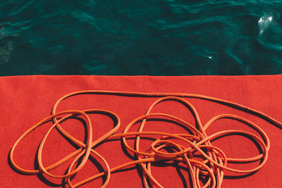 High angle view of rope by sea on sunny day