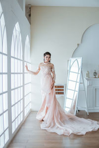 Portrait of bride standing against wall