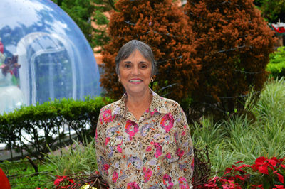 Portrait of senior woman standing against plants at park