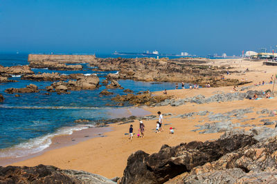 People on beach against blue sky