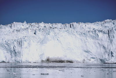 Scenic view of snow covered landscape against clear blue sky