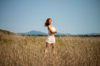 Woman standing on field against sky