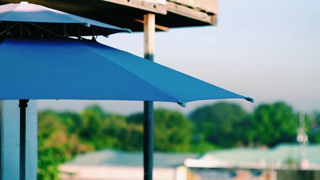 flag, blue, focus on foreground, tree, nature, sky, day, hanging, sunlight, outdoors, absence, no people, parasol, close-up, beach umbrella, chair, built structure, sea, boat, beach