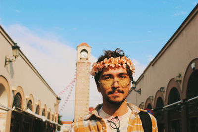 Portrait of young man smiling in the city behind historic old clock tower adana turkey