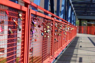 Padlocks on red footbridge railing