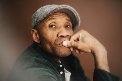 Contemplative mature man with beret in studio