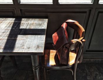 High angle view of bag on chair by table