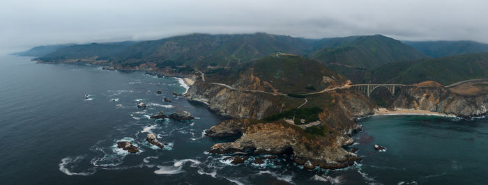 Scenic view of sea and mountains against sky