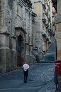 Man walking in front of building