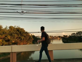 Full length of man standing by railing against sky
