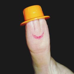 Close-up of man holding hand over black background