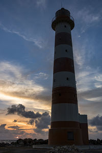 Low angle view of lighthouse against sky during sunset